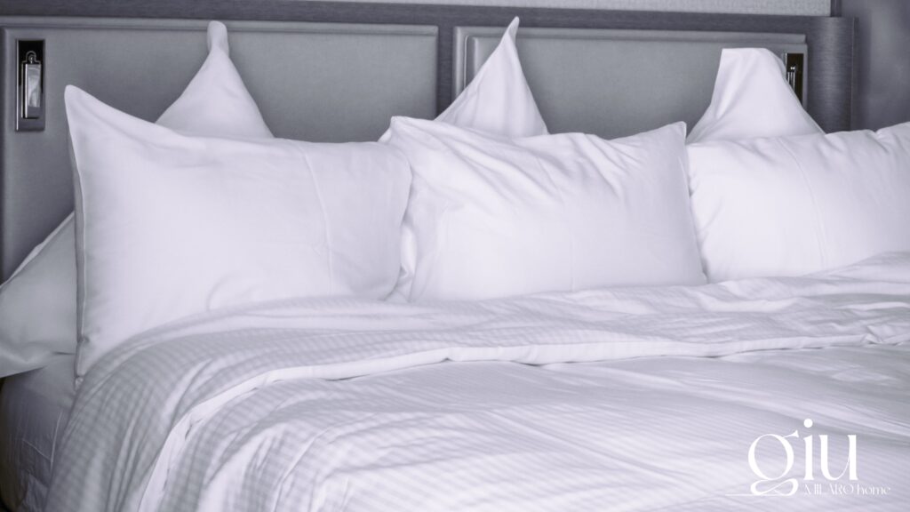 Komfortowe łóżko z białą pościelą i poduszkami - idealna podstawa dla najlepszych materacy do spania giu